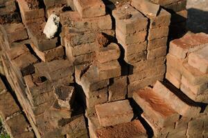 Textured Detail of mossy bricks on the side of the road. Photograph of piles of used bricks left over from house construction. Abstract Background. Construction Industry. Background Photgraphy. photo
