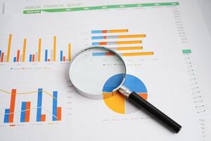 Magnifying glass on charts graphs paper. Financial development, Banking Account, Statistics, Investment Analytic research data economy. photo