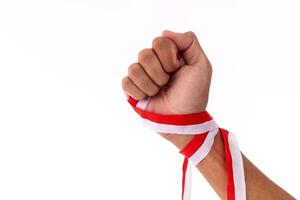 Man with strong arms and clenched fists holding red and white ribbons as a symbol of the Indonesian flag. Indonesian Independence day concept. photo