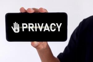 Privacy concept of private data. Man holding a smartphone with privacy written on screen. photo