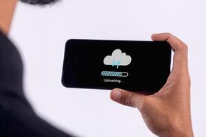 Phone data backup and cloud data storage concept. Man using a smartphone to upload data to cloud storage. photo