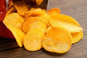 Potato chips, delicious BBQ seasoning spicy for crips, thin slice deep fried snack fast food in open bag. photo
