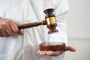 Doctor holding judge gavel, forensic medicine, medical law and crime justice concept. photo