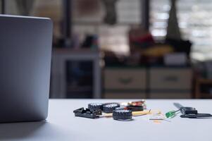 Stem education concept. A laptop sits on a table with various tools and parts scattered around it. The scene suggests that someone is working on a project or repair, possibly in a workshop or garage photo