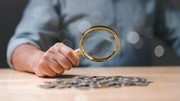 One person in business meticulously analyzes coins under magnifying glass, researching innovative concepts and strategies, discovering successful solutions and breakthrough ideas for financial growth photo