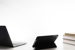 Education and learning with technology concept. Laptop and a tablet sit on a table with a stack of books. Scene suggests a study environment where multiple devices are used for Education in classroom photo
