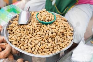 A person is sitting on a table with a bowl of peanuts in front of them photo