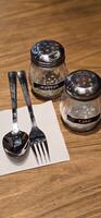 simple American diner style salt and pepper glass shakers sits on table with wooden background, selective focus background, good for recipe book or web blog photo