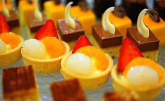 Beautiful multicolored decorated baked sweet tasty party cakes or catering cakes for party, bar dessert selection with cake, pie and pastries catering banquet, coffee break buffet at a conference photo