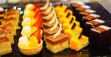 Beautiful multicolored decorated baked sweet tasty party cakes or catering cakes for party, bar dessert selection with cake, pie and pastries catering banquet, coffee break buffet at a conference photo