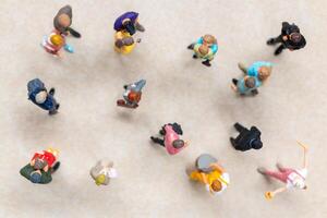 Top-down view of a group of miniature people showing different clothing and poses. photo