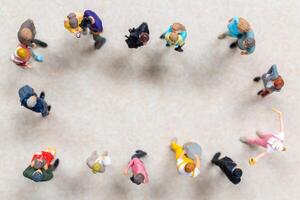 Top-down view of a group of miniature people showing different clothing and poses. photo