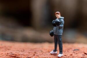 Miniature people, A man lifting dumbbells is set against a textured background photo