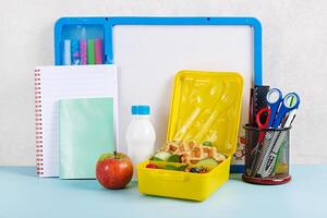 Kids lunch box with zucchini waffles, cucumber, cherry tomatoes and blueberries. Back to school breakfast background. Copy space. Top view, flat lay photo