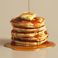 araffe with syrup and butter on top of a stack of pancakes photo