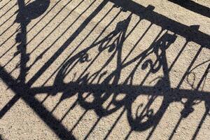 Light and shadow. Shadow of railing on the pavement photo
