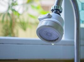 Faucet dripping water at the sink photo