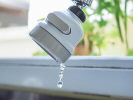 Faucet dripping water at the sink photo