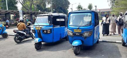 View of activity Bajaj parked on the side of the road around Senen market station waiting for passengers. Jakarta, Indonesia - June 8 2024 photo
