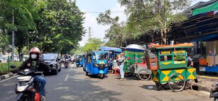 View of activity Bajaj parked on the side of the road around Senen market station waiting for passengers. Jakarta, Indonesia - June 8 2024 photo
