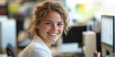 A cheerful young woman enjoys her work while sitting at a desk in a bright office photo