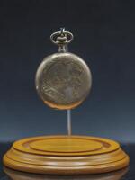 old gold pocket watch a family heirloom from an unclear lineage ago in its display case without the dome photo