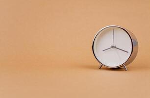 Alarm clock photography in a light brown background studio The concept of time and living and working photo