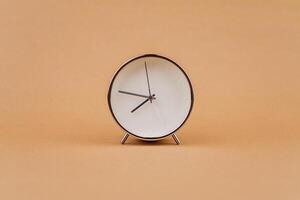 Alarm clock photography in a light brown background studio The concept of time and living and working photo