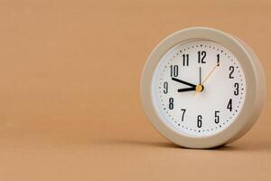 Alarm clock photography in a light brown background studio The concept of time and living and working photo
