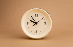 Alarm clock photography in a light brown background studio The concept of time and living and working photo