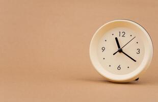 Alarm clock photography in a light brown background studio The concept of time and living and working photo