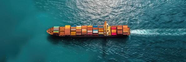 A large container ship with colorful cargo containers sails across a blue ocean photo