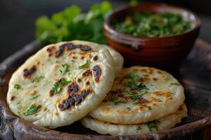 Close-up of Three Golden Brown Naan Breads with Cilantro Garnishes photo