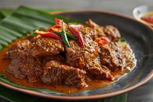 Spicy Beef Curry with Green Chilis on a Black Plate photo