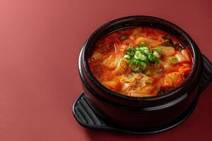 Spicy Kimchi Soup with Green Onions in Black Bowl photo