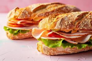 Two Turkey and Tomato Sandwiches on a Pink Surface photo