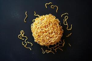 A Single Serving of Dried Noodles on a Black Surface photo