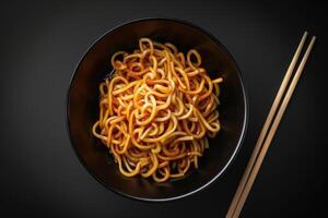 A Bowl of Noodles with Sauce and Chopsticks photo