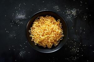 A Bowl of Noodles on a Black Surface with Sesame Seeds Scattered Around photo