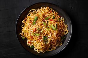 Noodles with Green Onions and Sesame Seeds in a Black Bowl photo