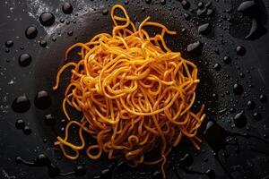 Golden Noodles with Spilled Soy Sauce on a Black Background photo