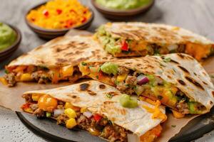 Closeup of Four Deliciously Filled Quesadillas with Guacamole and Pico de Gallo photo