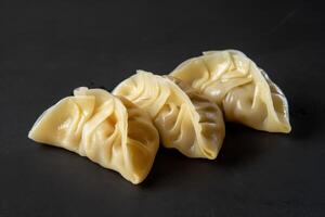Three Steamed Dumplings on Black Background photo