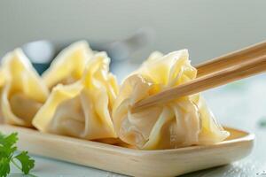 Closeup of Steamed Dumplings Being Picked Up With Chopsticks photo
