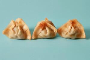 Three Steamed Dumplings on a Blue Background photo