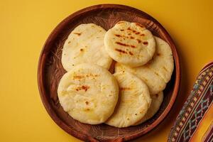 A Plate of Grilled Arepas on a Wooden Plate photo
