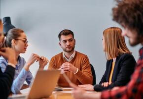 In the vibrant ambiance of a modern startup office, a diverse team of business professionals engage in discussions on various projects and develop new business strategies, epitomizing creativity and photo