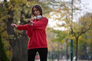 Athletic young woman taking a breath and relaxing after jogging and stretching. Woman Training and Workout Exercises On Street. photo