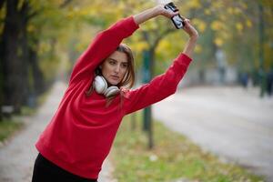 Athletic young woman taking a breath and relaxing after jogging and stretching. Woman Training and Workout Exercises On Street. photo