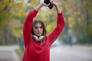 Athletic young woman taking a breath and relaxing after jogging and stretching. Woman Training and Workout Exercises On Street. photo
